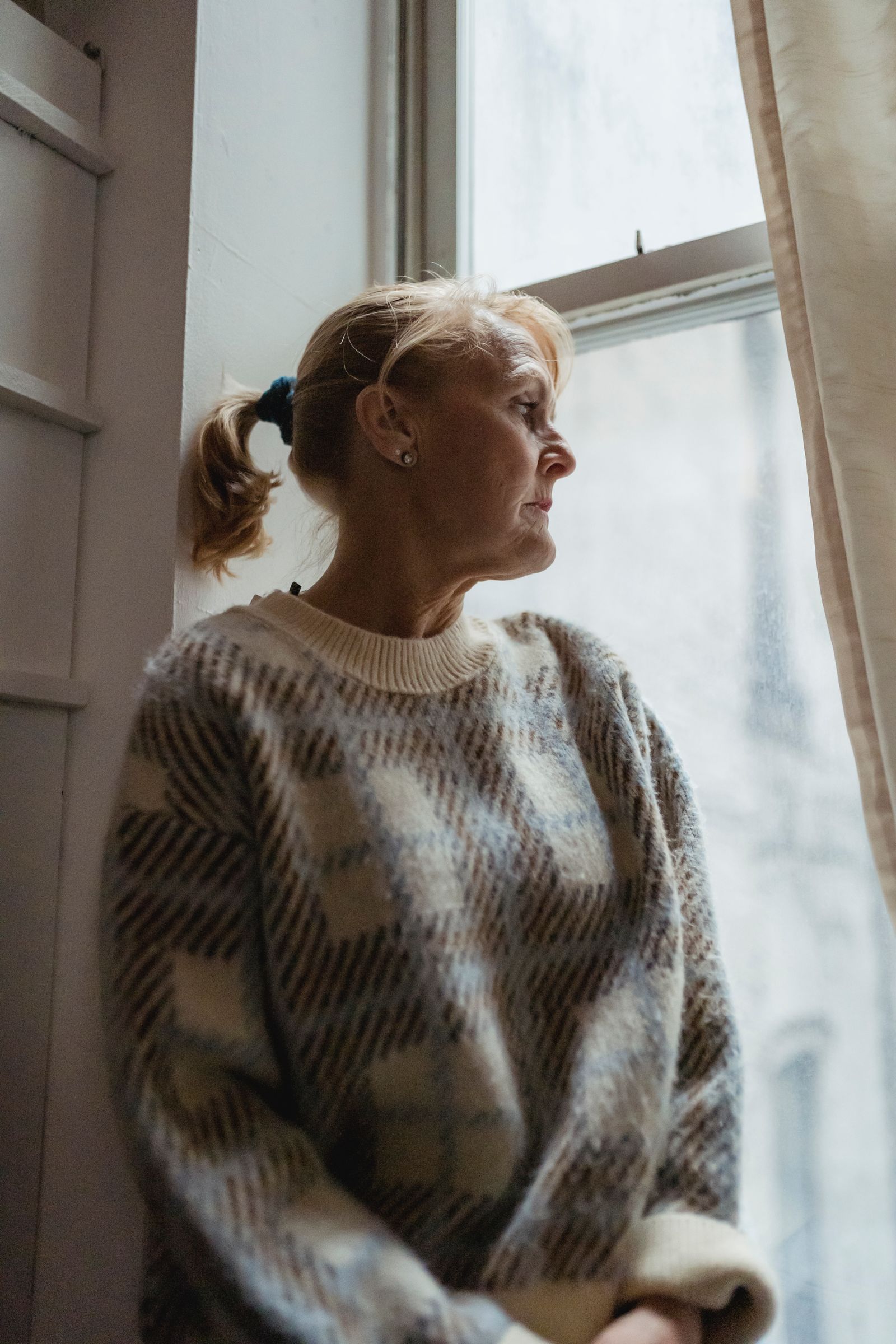 A woman resting, calm by a window